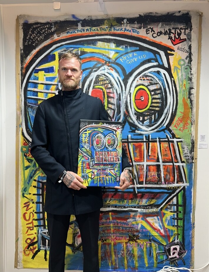 R.P. Gribben standing before T.P.M at the Paris exhibition and holding its print edition
