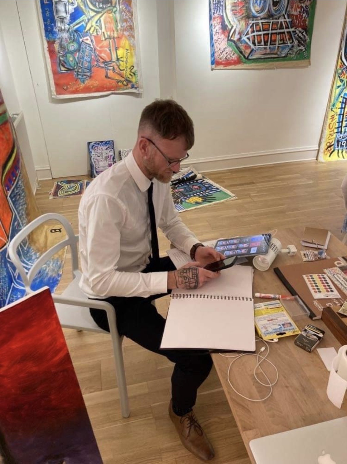 R.P. Gribben working from a sketchbook within an exhibition space