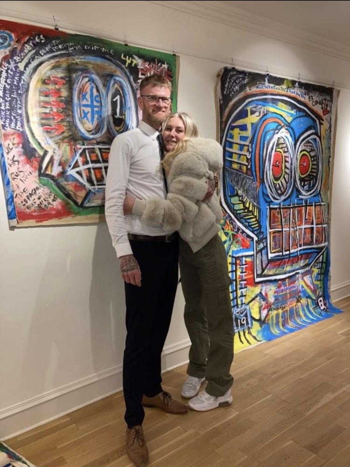 R.P. Gribben with a visitor in front of two exhibited paintings