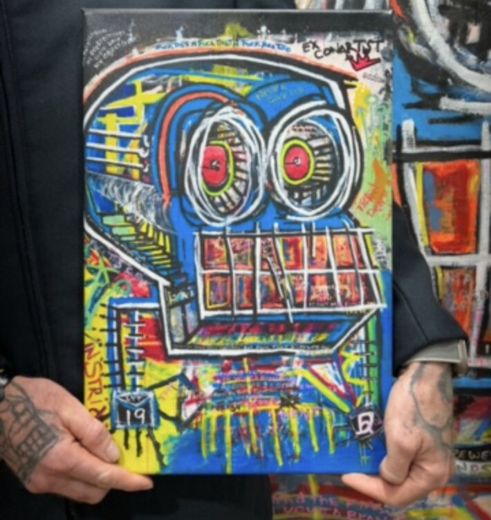 Close view of the print edition held before the original painting